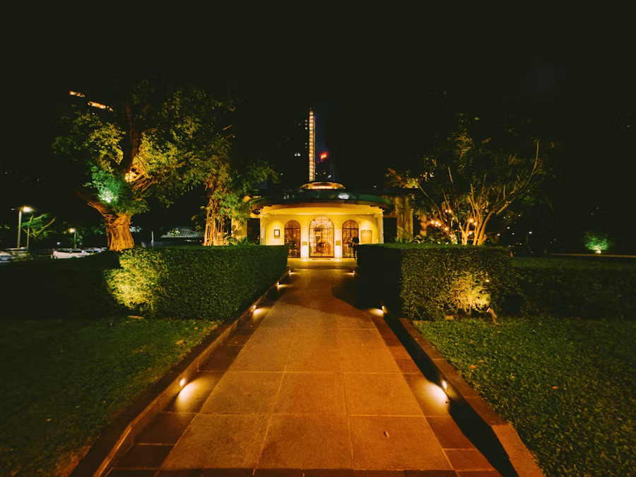 Dramatic night garden with outdoor lighting illuminating path and pavilion