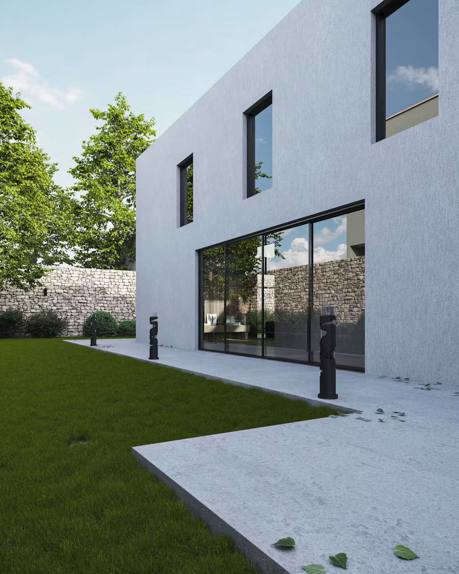Modern luxury home with manicured lawn, stone wall and outdoor lighting